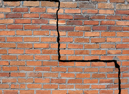 large crack in red brick wall