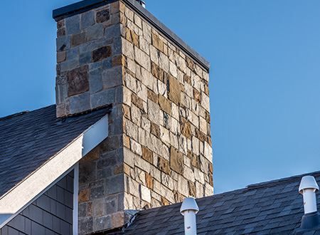 close up to Large stone chimney on the roof